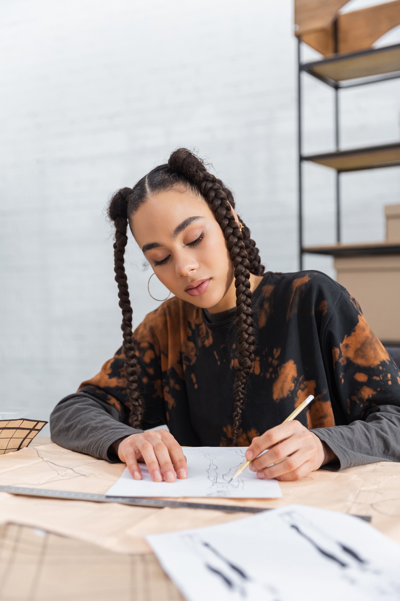 African american designer drawing sketch near blurred sewing pattern
